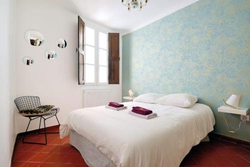 une chambre avec un grand lit blanc et une fenêtre dans l'établissement Appartement Vieille ville 55 m2 avec Terrasse 16m2 et 2chambres Vraie Climatisation, à Aix-en-Provence