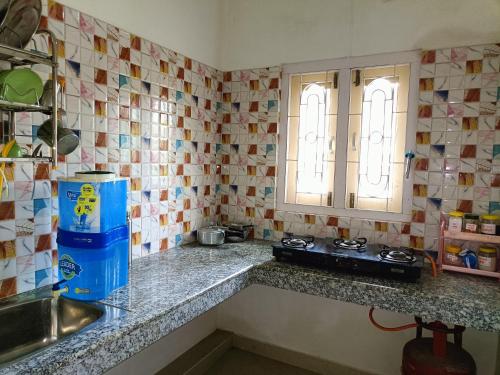 a kitchen with a counter and a sink and a window at Blueberry Homestay in Guwahati