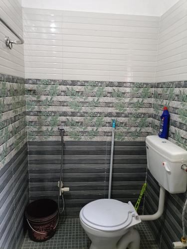 a bathroom with a white toilet in a room at Blueberry Homestay in Guwahati