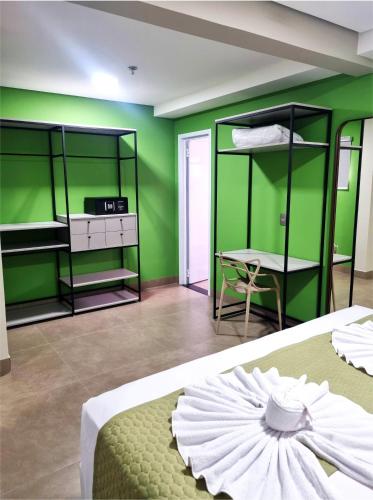 a room with green walls and bunk beds and a table at Brisas Flat Hotel in Cuiabá