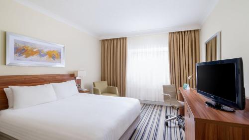 a hotel room with a bed and a flat screen tv at Holiday Inn Derby/Nottingham by IHG in Derby