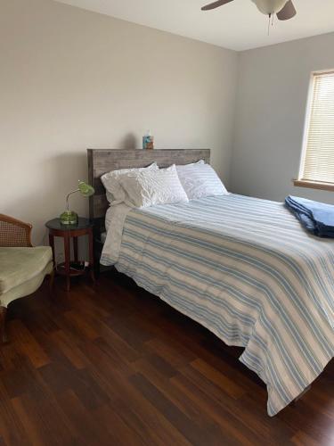 a bedroom with a bed with a striped comforter at Close to the Bozeman airport in Belgrade