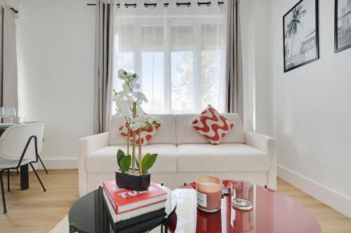 un salon avec un canapé blanc et une table dans l'établissement Beautiful apartment 8pers, à Paris