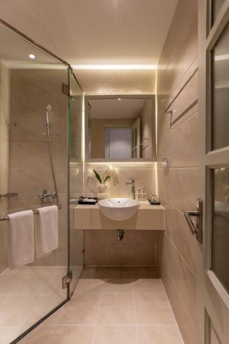 a bathroom with a sink and a shower at Keypad Hotel - Nhân Hòa in Hanoi