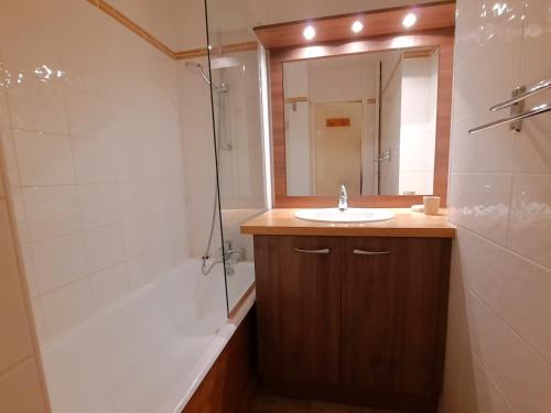 une salle de bain avec un lavabo, une douche et un miroir dans l'établissement Studio au pied des pistes, balcon sud, coeur des Ménuires, 4 pers. - FR-1-452-142, aux Menuires