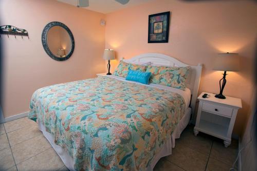 a bedroom with a bed and two lamps and a mirror at Courtney's Place Historic Cottages & Inns in Key West