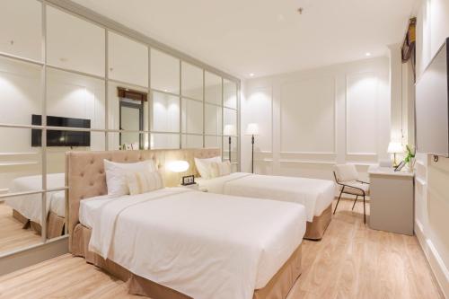 a hotel room with two beds and a mirror at Keypad Hotel - Nhân Hòa in Hanoi
