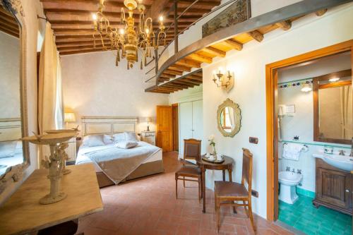 a bedroom with a bed and a table and a chair at AMORE RENTALS - Villa Il Casello in Greve in Chianti
