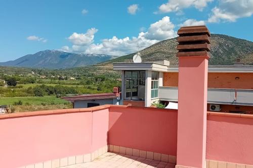 a pink house with mountains in the background at Tivoli, la terrazza di Bamby in Tivoli