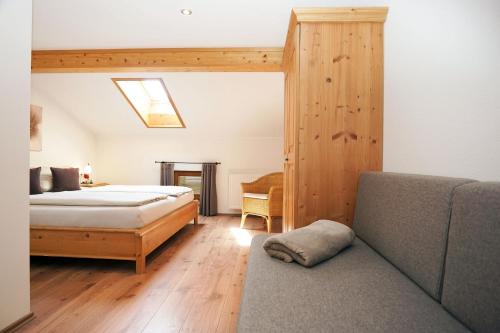 a bedroom with a bed and a couch at Sotterhof - Chiemgau Karte in Inzell