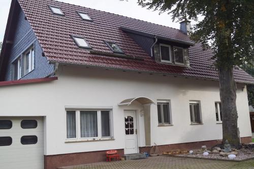 a white house with a red roof at FEWO Thüringer Becken in Sömmerda