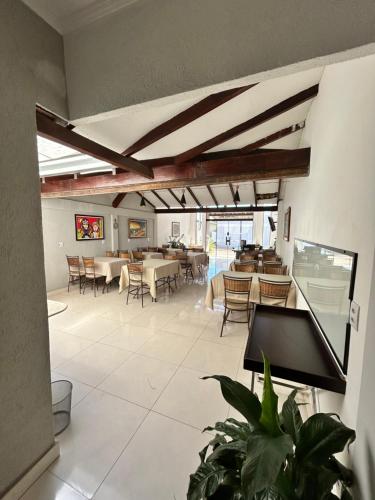 a living room with tables and chairs and a dining room at Trembão Hotel & Suítes in Ribas do Rio Pardo