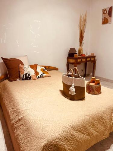 un lit avec deux sacs dessus avec une table dans l'établissement Chambre terracotta, à Orgères