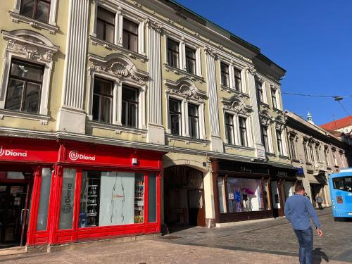 un homme marchant dans une rue devant un bâtiment dans l'établissement Studio apartman Mia, à Zagreb