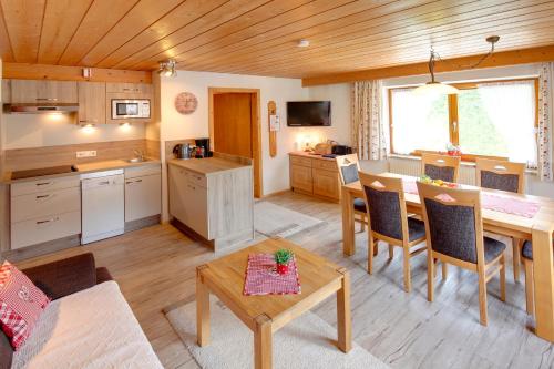 a kitchen and living room with a table and chairs at Haus Seebach in Berwang