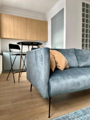 a blue couch in a living room with a table at Šiauliai CENTER Višinskio NEW self check In in Šiauliai
