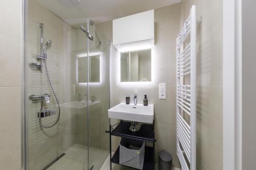 a white bathroom with a sink and a shower at Terrace View Apartment - Golden Apartments Rezidence Nová Karolina in Moravská Ostrava