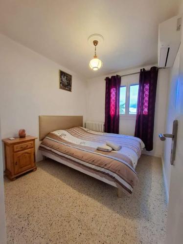 une chambre avec un lit, une commode et une fenêtre dans l'établissement Appartement F3 proche de la mer, à Cagnes-sur-Mer