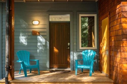 two blue chairs sitting on the front porch of a house at Pacific Forest Beach House in Parksville