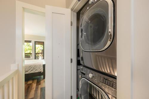 a kitchen with a microwave and a washer and dryer at Pacific Forest Beach House in Parksville