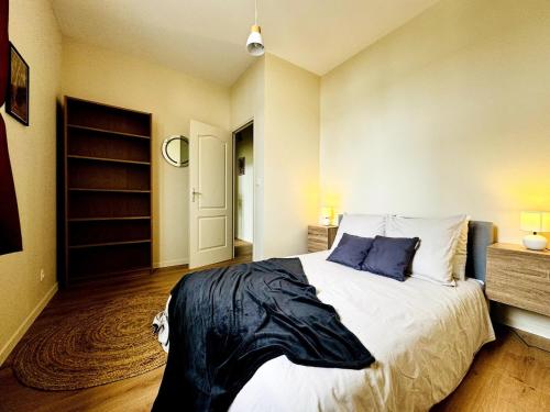 a bedroom with a large white bed with blue pillows at Le Saint - By 69ALSACELO- 3 Chambres Séparées - Idéal Pro & Famille - Patio Privé - Proche Centre Ville - Smart TV - WiFi Fibre - Check-in Autonome - Parking Facile & Gratuit in Sens