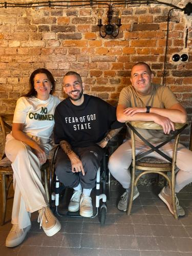 a group of three people sitting next to a brick wall at VILLA ANGEL in Rožňava