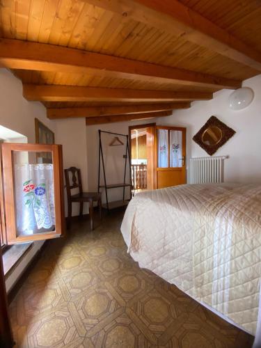 a bedroom with a bed in a room with wooden ceilings at Casa nel centro storico di Borno in Borno