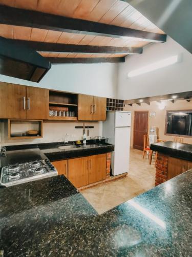 a kitchen with black counter tops and a white refrigerator at Posada San Miguel in Paraguarí