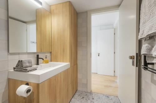 un bagno con lavandino e specchio di Oceanfront Lux Condo Sleeps 9 a Cascais