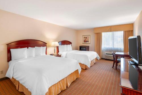 a hotel room with two beds and a flat screen tv at Best Western Plus West Covina Inn in West Covina