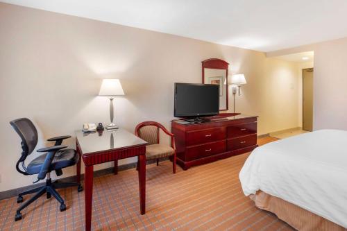 a hotel room with a bed and a desk and a television at Best Western Plus West Covina Inn in West Covina