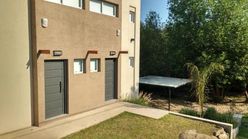 a building with two garage doors and a bench at Cabañas Paititi in Villa Carlos Paz