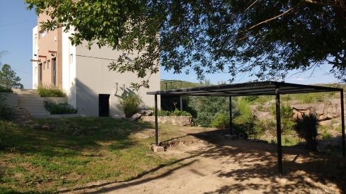 a black canopy in a yard with a building at Cabañas Paititi in Villa Carlos Paz
