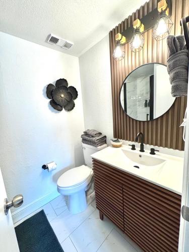 a bathroom with a toilet and a sink and a mirror at Home Cheti - Apartment near Universal Studios in Orlando