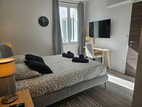 une chambre avec un lit, un bureau et une télévision dans l'établissement Belle Maison Loft patio jacuzzi clim Tours, à Tours