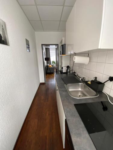 a kitchen with a sink and a wooden floor at City Nowa 1 in Nürnberg