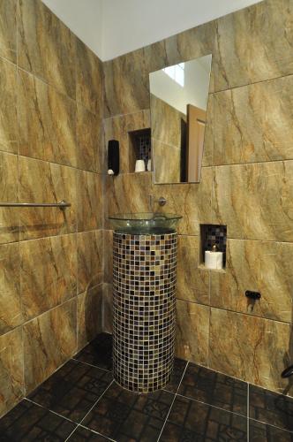 a bathroom with a trash can and a mirror at Kevin Resort in Thang Kwian