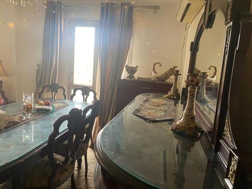 comedor con mesa de cristal y espejo en Females only Private bedroom stay with me Rehab city, en El Cairo