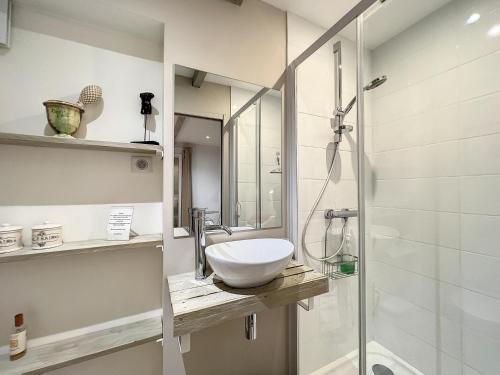 une salle de bain avec un lavabo et une douche en verre dans l'établissement La maison blanche Intra-Muros Free parking, à Aigues-Mortes