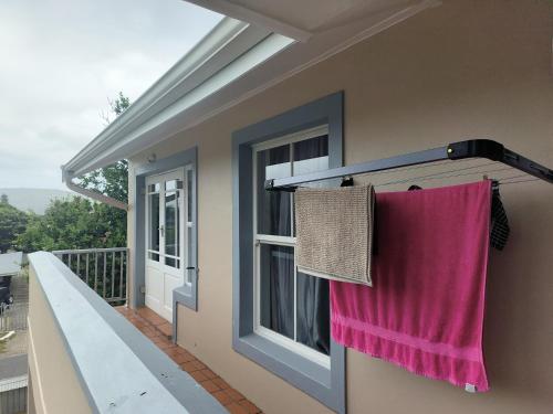 a house with a pink towel hanging on a balcony at Sunny Side Apartment in Knysna