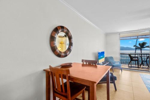 a dining room with a table and a mirror on the wall at Maalaea Kai 311 - Direct Ocean Front, Split AC in Wailuku