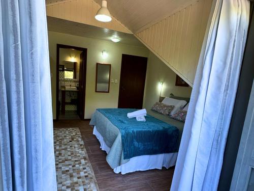 a bedroom with a bed with a blue blanket at Pousada da Baronesa in Nova Petrópolis