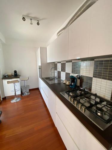 a kitchen with white cabinets and a black counter top at Casa Morena in Rome