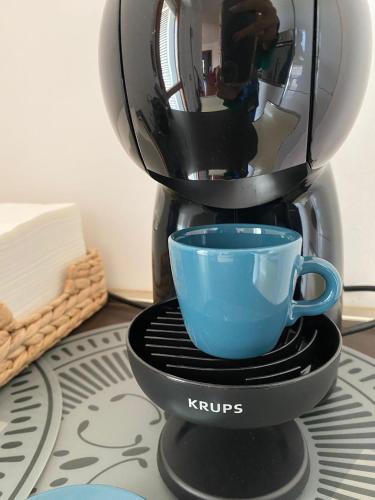 a coffee maker with a blue cup on a stand at Casa Morena in Rome
