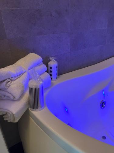 a bathroom with a blue tub with towels on it at Casa Morena in Rome