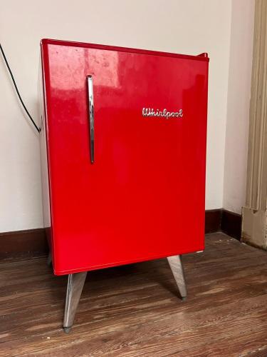 a red refrigerator sitting on top of a wooden floor at HOSTEL COLIVING STUDIO JUNIN in Junín