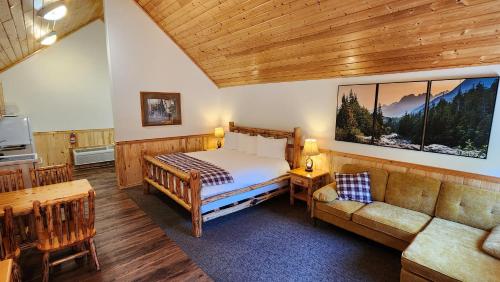 a bedroom with a bed and a couch in a room at Beargrass Lodging & RV Resort in Hungry Horse