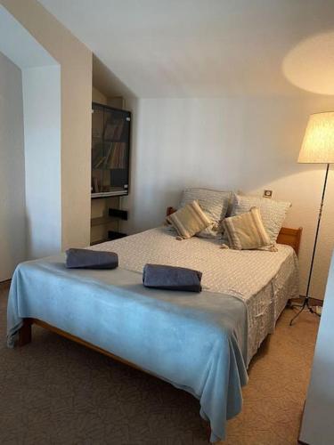 une chambre avec un lit avec deux oreillers dessus dans l'établissement Duplex 6 pers 200m plage centre ville, à Sainte-Maxime