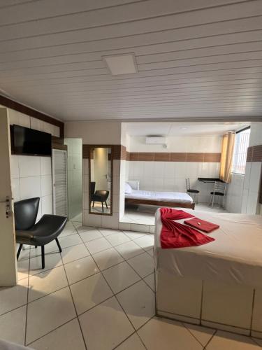 Camera con letto, sedia e TV di Boa Viagem a Feira de Santana