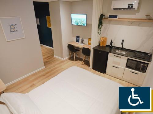 a room with a bed and a kitchen with a table at Apê Brás - Shopping Plaza Polo in Sao Paulo